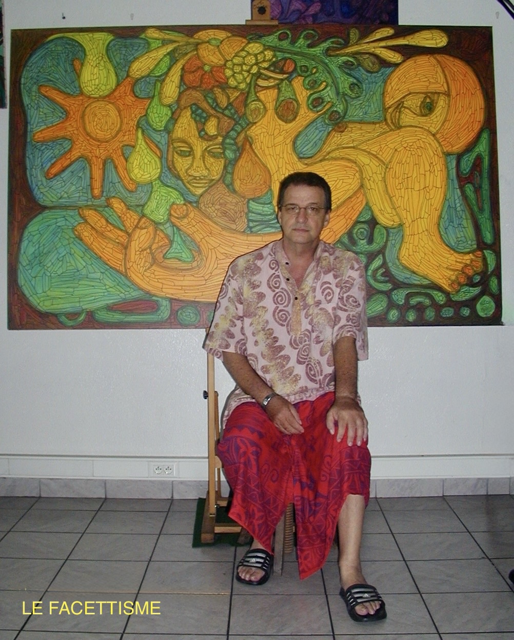 Mathius TO’ERAU wearing a pareo in front of a Facettist work